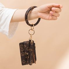 a person holding onto a keychain with two charms attached to it's sides