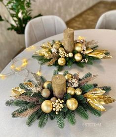 two centerpieces on top of a table covered in gold and silver decorations with candles