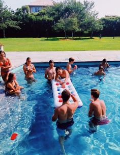 a group of people sitting around in a pool with an inflatable raft on it