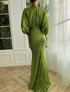 Let yourself be carried away by the breathtaking vivid green dress. Its sparkling lace fabric gives an unparalleled charm to your appearance. Carefully crafted, the loose turtleneck and mermaid silhouette complement each other beautifully.