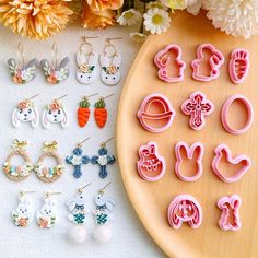 various earrings and earring sets on a table next to flowers