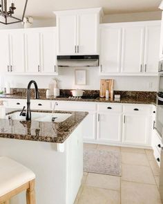 a kitchen with white cabinets and granite counter tops