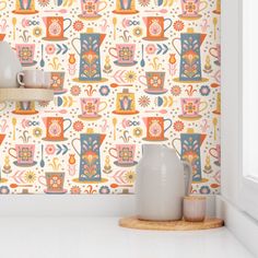 the wallpaper in this kitchen is colorful and has many cups on top of it