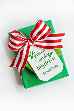 a present wrapped in green paper with a red and white ribbon on it's side