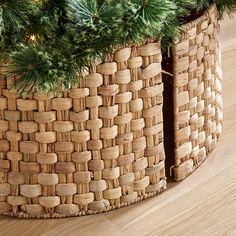 a close up of a basket on the floor with a christmas tree in front of it