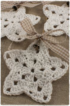 three crocheted stars are tied to burlock