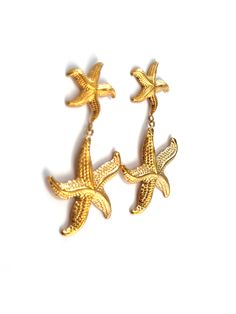 Dive into seaside charm with the "Starfish Earrings" – a delightful pair featuring a larger starfish dangling from a smaller one, both in radiant gold. These earrings capture the whimsy of the ocean, adding a playful touch to your style. Embrace the coastal allure with this charming accessory that evokes the beauty of starfish by the shore. 18k Gold Plated Nickel Free & Hypoallergenic Starfish Earrings, Adventure Style, Resort Collection, Earring Sale, Starfish, 18k Gold, Gold Plate, Plating, Gold