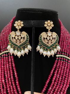 This necklace is a statement piece with a beautiful red/magenta shade and comes with a matching pair of earrings. The length can be adjusted accordingly. The work is high quality stones with a great shine. The necklace comes with statement earrings that can be worn by itself for a simple look. Elegant Stone Earrings For Festive Occasions, Kundan Earrings With Stones For Celebration, Festive Traditional Earrings With Stones, Elegant Ruby Earrings With Stone Work, Festive Stone Earrings, Temple Jewelry Earrings With Stones For Celebration, Festive Earrings With Stones As Gift, Bollywood Ruby Jewelry With Matching Earrings, Handmade Elegant Chandbali Bridal Necklace