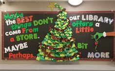 a christmas tree made out of books on a bulletin board