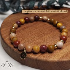 MOOKAITE JASPER BEADED BRACELET WITH 14KT GOLD FILLED ACCENTS HEALING PROPERTIES: Mookaite Jasper is thought to be a physically stabilizing stone, it brings well-being, strengthening the immune system, heals wounds and purifies the blood. Mookaite is believed to be a healing stone of Mother Earth, containing sacred earth energies that can be harnessed for healing the plane. DESIGN: 6mm natural stones with 14kt gold filled spacers and charm. Each gemstone bracelet comes with a FREE ESSENTIAL OIL DIFFUSER BRACELET! These are made of either natural lava stones or rosewood. We aim to pair the color of the complimentary essential oil bracelet to your unique bracelet's characteristics, but if you want lava stone more than rosewood (or vice versa) just leave us a message in "Note to Seller."  MAT Gold Stretch Bracelet With Natural Stones For Everyday, Gold Bracelets With Polished Beads For Healing, Spiritual Brown Hypoallergenic Jewelry, Brown Hypoallergenic Spiritual Jewelry, Hypoallergenic Brown Spiritual Jewelry, Everyday Hypoallergenic Brown Jewelry, Reminder Bracelets, Oil Bracelet, Sacred Earth