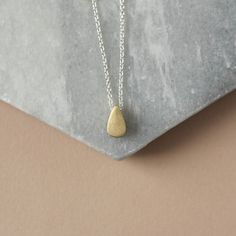 Minimal Mixed Metal Necklace - Two Tone Layering Necklace - Simple Everyday Necklace This trendy mixed metal necklace is perfect for every day and so easy to style with other jewelry. It features a raw brass teardrop paired with sterling silver cable chain for a nice contrast of tones. The teardrop is petite at 9mm tall and 5mm wide but it's also 5mm thick so the charm has some nice depth to it.  The teardrop has been given a brushed textured for some matte gold hue. The charm slides freely alon Everyday Brass Teardrop Necklace, Everyday Teardrop Brass Necklace, Nickel-free Teardrop Pendant Necklace For Everyday, Everyday Nickel-free Teardrop Pendant Necklace, Gold Teardrop Pendant Necklace, Nickel Free, Everyday Teardrop Charm Necklace With Delicate Chain, Gold Teardrop Charm Necklace For Everyday, Everyday Gold Teardrop Charm Necklace, Silver Brass Teardrop Necklace