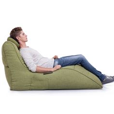 a man sitting on a bean bag chair with his feet propped up against the back