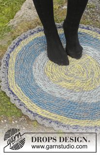 a person standing on top of a blue and yellow rug with black boots in it