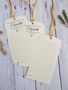 two personalized notepads with ribbons and twine on white wooden table top