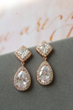 Rose gold vintage style zircon  earrings  Great for you or for your bridesmaids. Colour: rose gold /clear Stud earrings. Measurements: approx 3.5 cm, width approx  x 12mm . Materials:  rhodium over brass  components, zircon crystals. SAME STYLE in silver/blue: https://www.etsy.com/uk/listing/976619935/something-blue-wedding-earrings-for?ref=shop_home_active_1 SAME STYLE in silver/clear tone: https://www.etsy.com/uk/listing/962646758/wedding-earrings-for-brides-art-deco?ref=shop_home_active_2 Gre Art Deco Earrings Wedding, Rose Gold Wedding Earrings, Blue Earrings Wedding, Gold Art Deco Earrings, Gold Wedding Earrings, Rose Gold Earrings Wedding, Teardrop Bridal Earrings, Bridesmaid Pearl Earrings, Wedding Studs