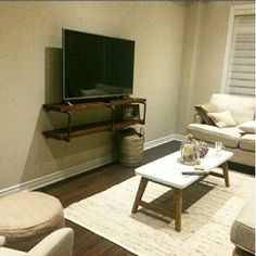 a living room filled with furniture and a flat screen tv on top of a wooden stand