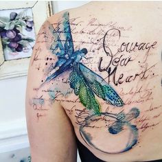 a woman with a dragon tattoo on her back that reads courage your heart and has writing all over it