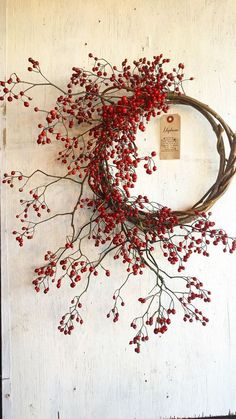 a wreath with red berries hanging on the wall