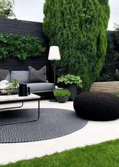 an outdoor living area with black and white furniture