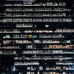 a very tall building with lots of windows in it's facade at night time