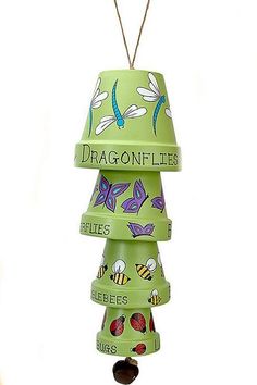 a green bird feeder with dragonflies painted on it's sides and the words