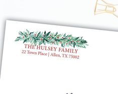 an envelope with holly leaves and red berries on it