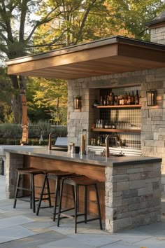 an outdoor bar with stools next to it