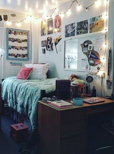 a bedroom with lights strung from the ceiling and pictures on the wall above it, along with a bed