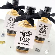 three bottles of cheeses to 30 years are tied with black ribbon and placed on a white plate