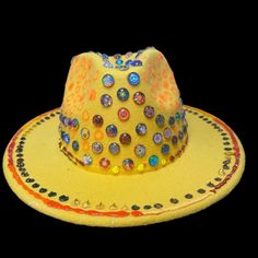 Description: Stand out at your next festival with this stunning handcrafted yellow fedora, embellished with vibrant 3D circular designs. Each piece is uniquely designed to react to UV light, making it the perfect accessory for night parties, Burning Man, and other rave events. This custom art hat was meticulously created by Ilgaz Kuren, blending artistic expression with festival fashion. With its eclectic mix of colors and detailed accents, this hat adds a pop of flair to any outfit. Features: U Rave Hats, Circular Designs, Festival Mode, Night Parties, Uv Reactive, Artistic Expression, Burning Man, Uv Light, Party Night