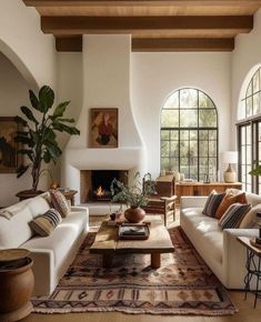 a living room filled with furniture and a fire place in the middle of a room