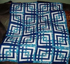 a blue and white quilt sitting on top of a couch