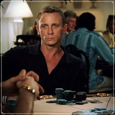 a man is sitting at a table with poker chips in front of him and other people around him