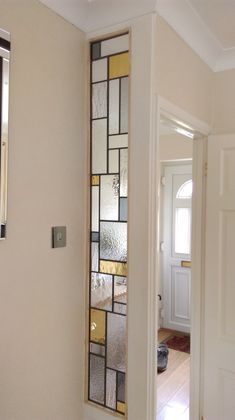 an open door with a stained glass window in the middle and a hallway leading to another room