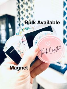 a person holding up a pink sticker with the words, bulk available and magnet