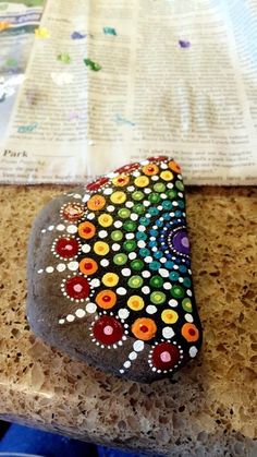 a rock painted with colorful dots on it