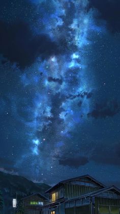 the night sky is filled with stars and clouds above some small buildings in front of a mountain