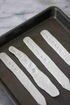 four white plastic spoons sitting on top of a pan