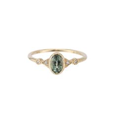 a gold ring with an oval green and white stone in the middle, surrounded by small diamonds