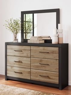 a dresser with a mirror and vases on it