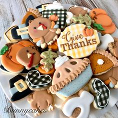 a white plate topped with lots of cookies and decorated like turkeys, bears, pumpkins