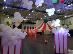 a circus tent with balloons and streamers on the ceiling