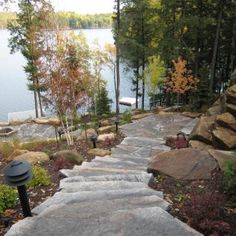 stone steps lead up to a lake with trees in the background