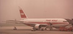 a red and white jet airliner sitting on top of an airport tarmac