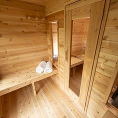 the inside of a sauna with wooden walls and benches, towels on each side