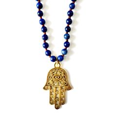 Handcrafted Necklace, hand knotted Lapis Lazuli chain measuring 36", vintage large hand of hamsa pendant, silk velvet emerald green ribbon with a tiny hand and a heart protective evil eye, and vintage brass danglers. The Hamsa Hand is a universal sign of protection, power, and strength that dates back to ancient Mesopotamia. It's believed to protect against the evil eye and all negative energies. Necklace measures 36" in length Lapis Lazuli gemstones hand-knotted Vintage Hand of Hamsa Made with Hand-strung Brass Jewelry For Gift, Hand-strung Brass Jewelry Gift, Spiritual Bronze Hand Wrapped Necklaces, Bronze Spiritual Hand Wrapped Necklaces, Spiritual Hand-knotted Jewelry For Festivals, Hand Knotted Spiritual Jewelry For Festivals, Bohemian Good Luck Jewelry With 108 Beads, Spiritual Hand Wrapped Brass Necklace, Bohemian Hand Knotted Gold Jewelry