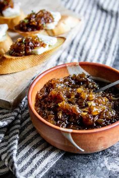 a bowl of food sitting on top of a table next to a wooden cutting board