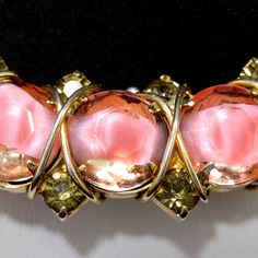 *Description: This is a beautiful brooch by Hattie Carnegie with pink art glass and gray rhinestones which have been wire wrapped on a gold plated backing from the 1960s. The brooch has a raised cartouche on the back with her name. I tested the gold surface and it tested at 10K gold surface metal. The pink art glass is actually a clear glass with the pink inside which gives the appearance of a flower petal or pink item inside the clear faceted glass. It is a unique brooch which is obviously desi Pink Brooch Jewelry For Evening, Pink Evening Brooch Jewelry, Pink Evening Jewelry Brooch, Pink Evening Brooches, Vintage Pink Brooches For Evening, Pink Vintage Brooches For Evening, Hattie Carnegie Brooch, Vintage Pink Metal Bracelets, Antique Pink Brooch Jewelry