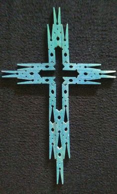 a cross made out of metal on a black surface