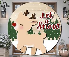 a wooden sign that says let it snow with a deer in front of some trees